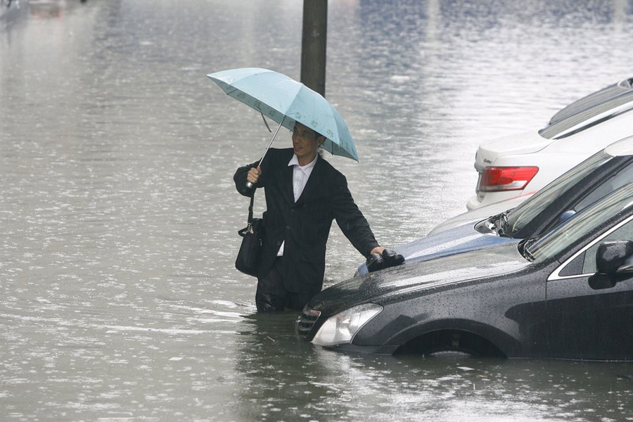 武汉暴雨路面被淹男子蹚水过街